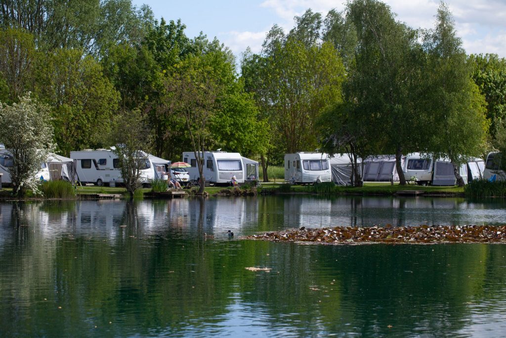 A group of caravans along the edge of the lake at Brickyard Lakes – a great spot for those looking to buy a static caravan! 